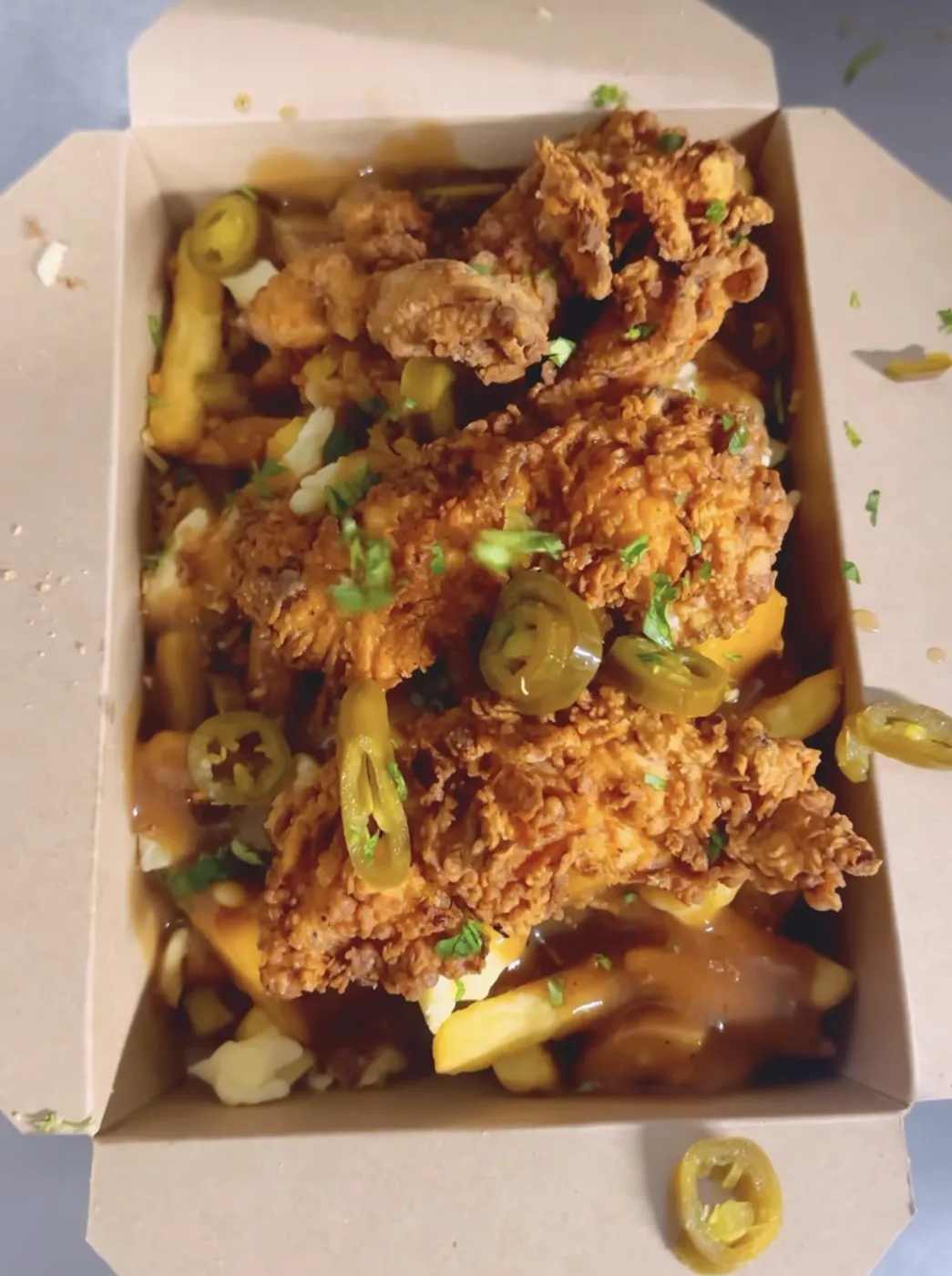 Loaded chips with fried chicken, gravy and jalapeños